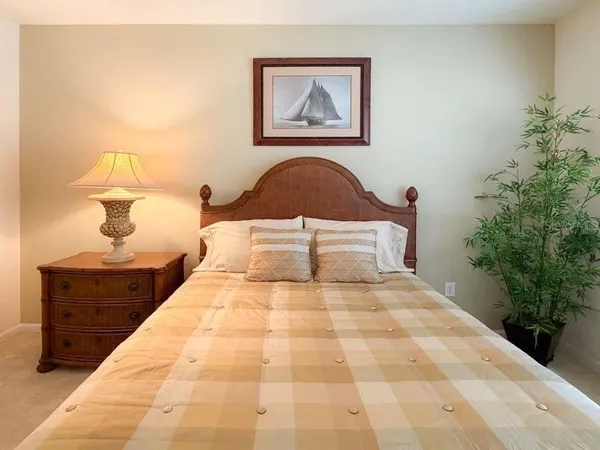 a bedroom with a bed and a potted plant