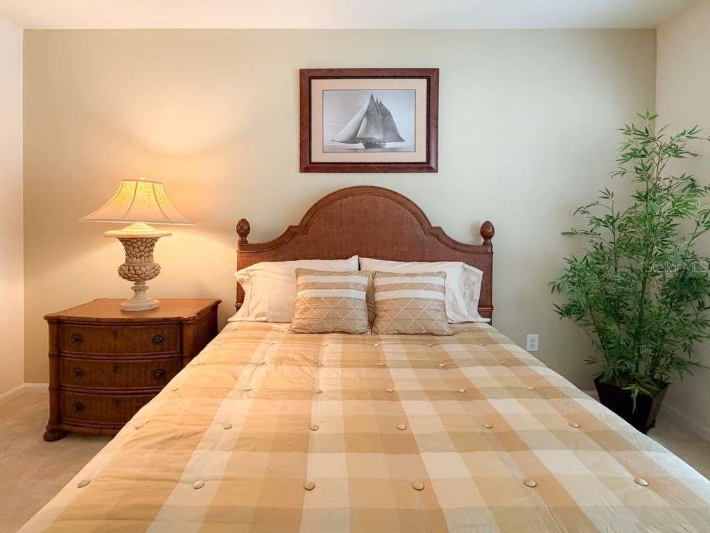 12843 Madison Pointe Circle, Unit 107 Orlando, FL 32821 - Photo 20 of 26 a bedroom with a bed and a potted plant