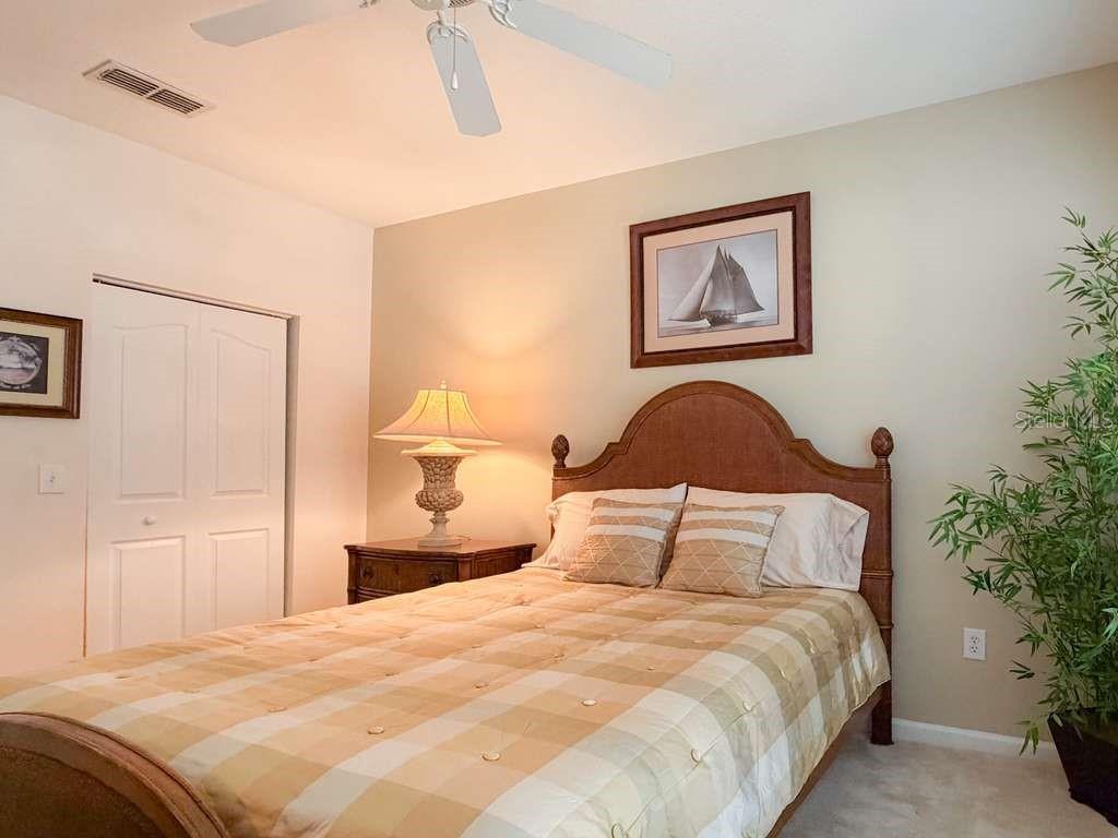 12843 Madison Pointe Circle, Unit 107 Orlando, FL 32821 - Photo 21 of 26 a bedroom with a bed and a painting on the wall