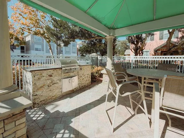 a view of a chairs and table in patio with swimming pool