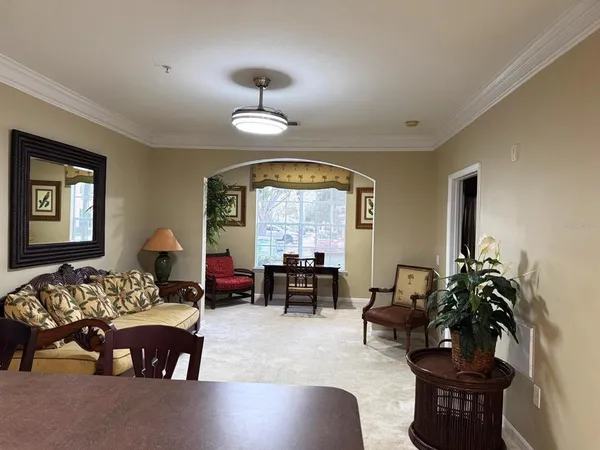 a living room with furniture chandelier and window
