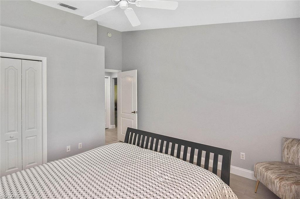 8075 Tiger Cove, Unit 1711 Naples, FL 34113 - Photo 14 of 42 a bedroom with a bed and wooden floor