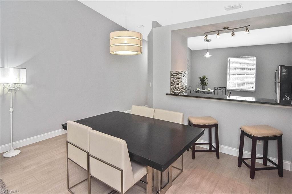 8075 Tiger Cove, Unit 1711 Naples, FL 34113 - Photo 15 of 42 a view of kitchen island with granite countertop cabinets table and chairs