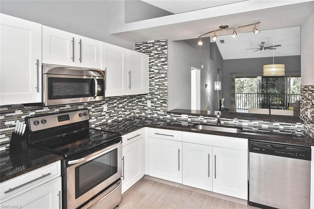 8075 Tiger Cove, Unit 1711 Naples, FL 34113 - Photo 21 of 42 a kitchen with white cabinets and appliances