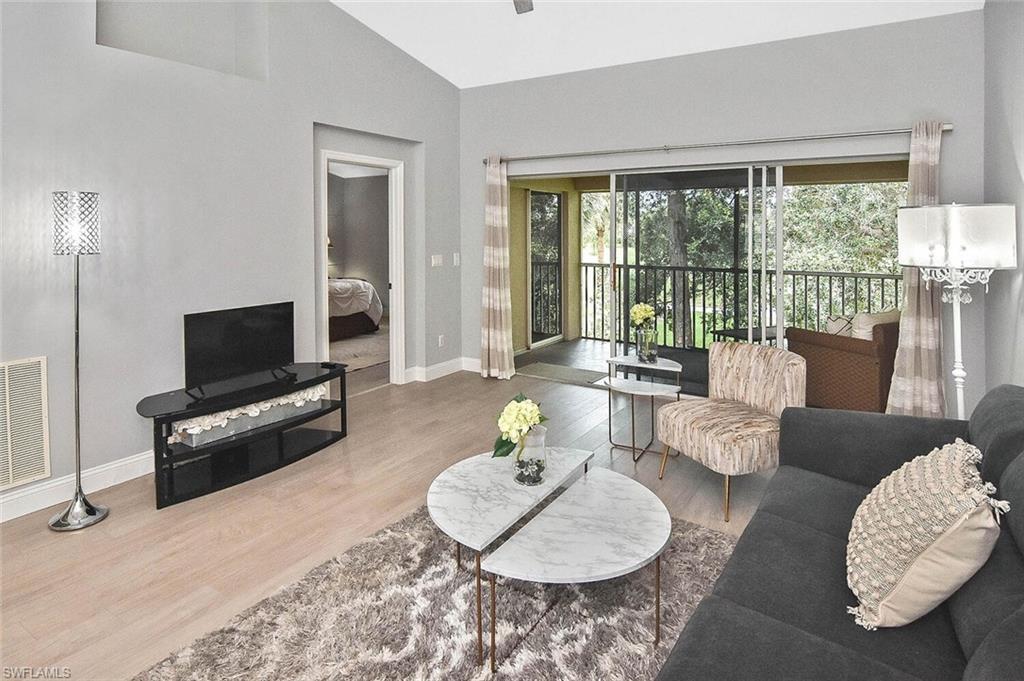 8075 Tiger Cove, Unit 1711 Naples, FL 34113 - Photo 23 of 42 a living room with furniture and a flat screen tv