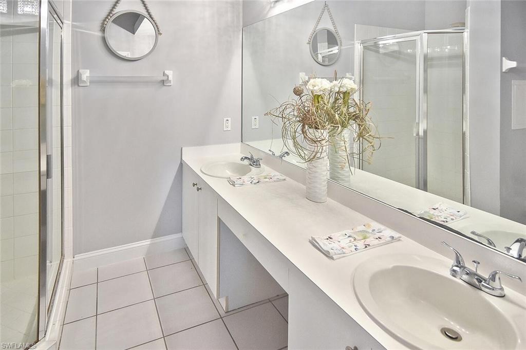 8075 Tiger Cove, Unit 1711 Naples, FL 34113 - Photo 31 of 42 a bathroom with a sink vanity and a mirror