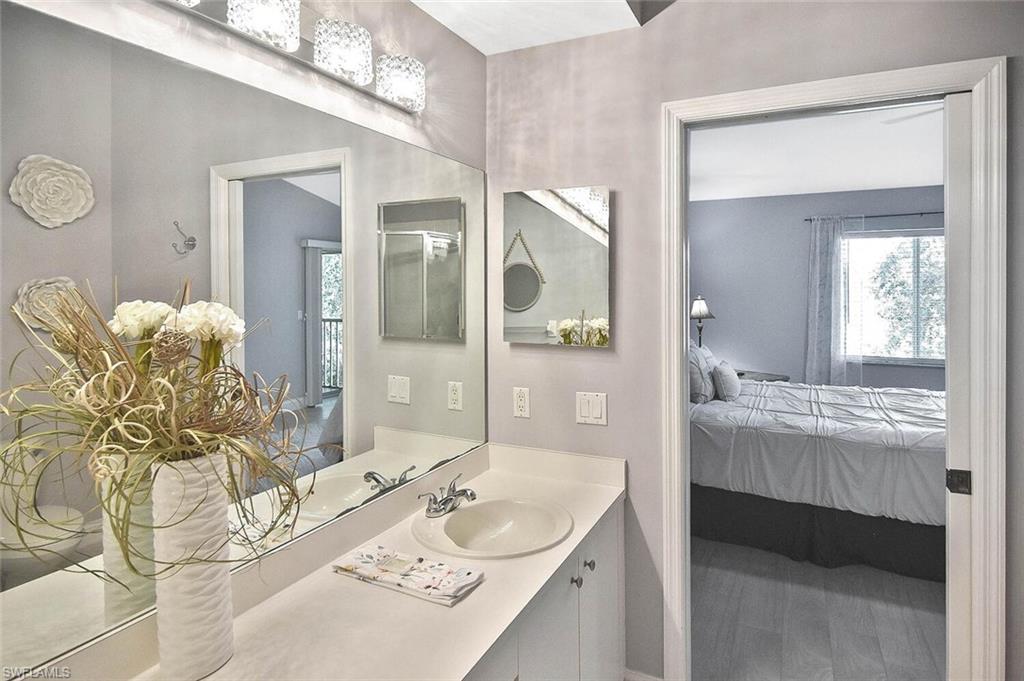 8075 Tiger Cove, Unit 1711 Naples, FL 34113 - Photo 33 of 42 a bathroom with a granite countertop sink and a mirror