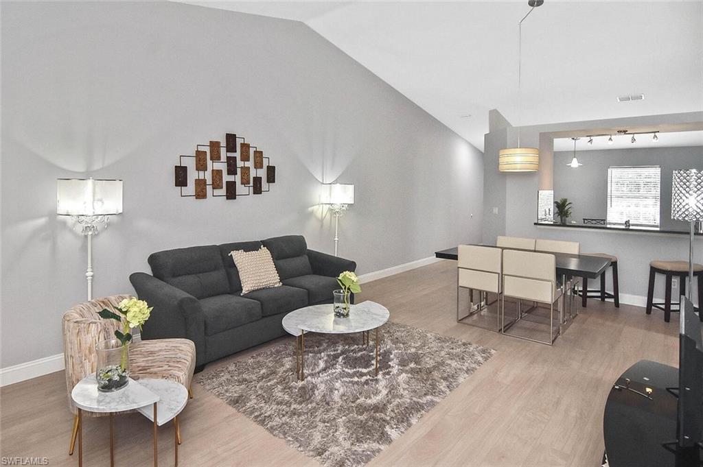 8075 Tiger Cove, Unit 1711 Naples, FL 34113 - Photo 35 of 42 a living room with furniture and a table