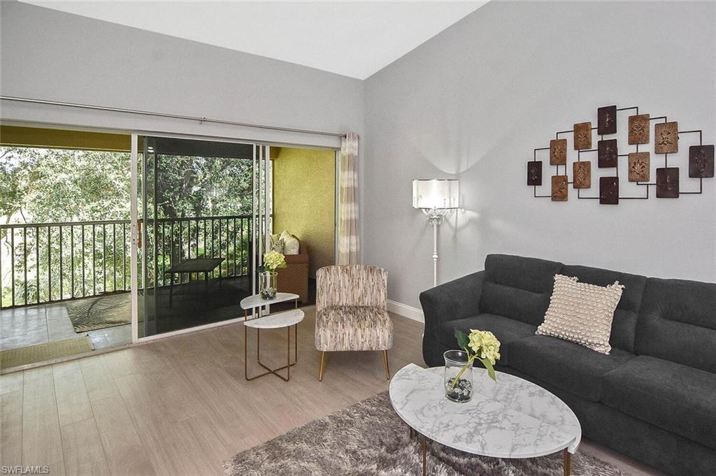 8075 Tiger Cove, Unit 1711 Naples, FL 34113 - Photo 36 of 42 a living room with furniture and a large window