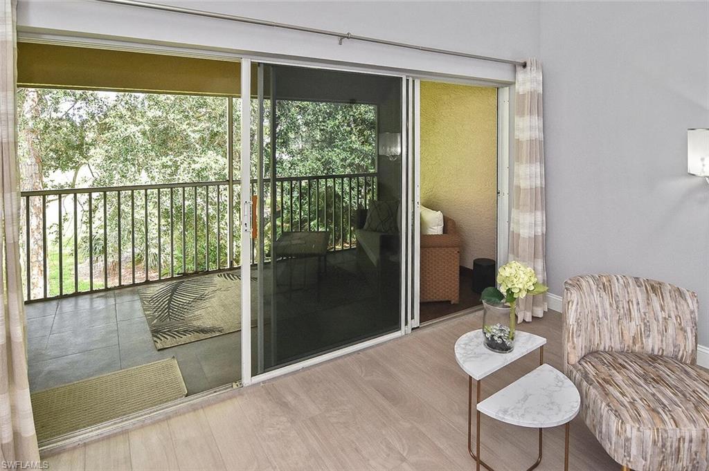 8075 Tiger Cove, Unit 1711 Naples, FL 34113 - Photo 37 of 42 a living room with furniture and a floor to ceiling window