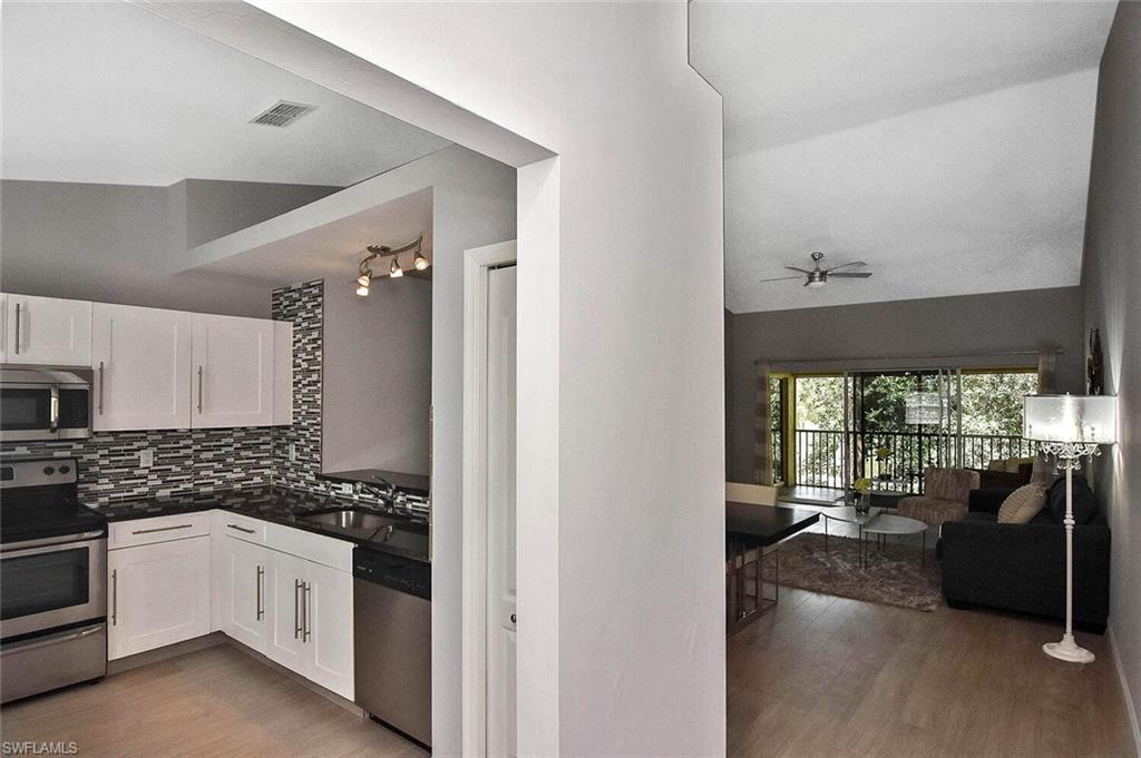 8075 Tiger Cove, Unit 1711 Naples, FL 34113 - Photo 4 of 42 a kitchen with a counter top space a sink stainless steel appliances and cabinets