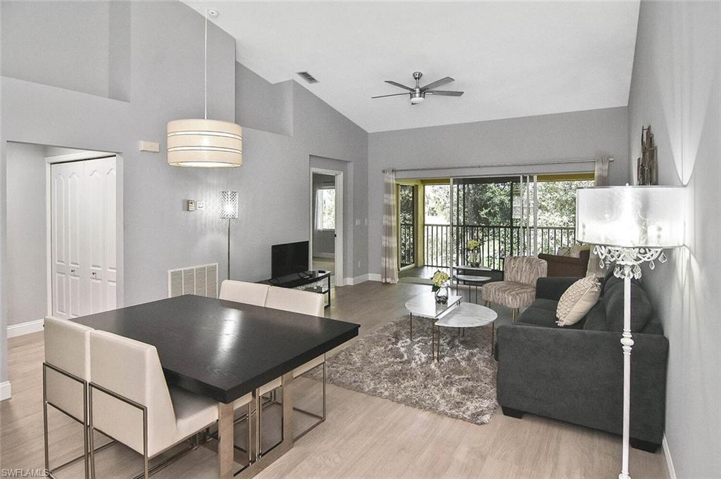 8075 Tiger Cove, Unit 1711 Naples, FL 34113 - Photo 5 of 42 a living room with furniture and a large window