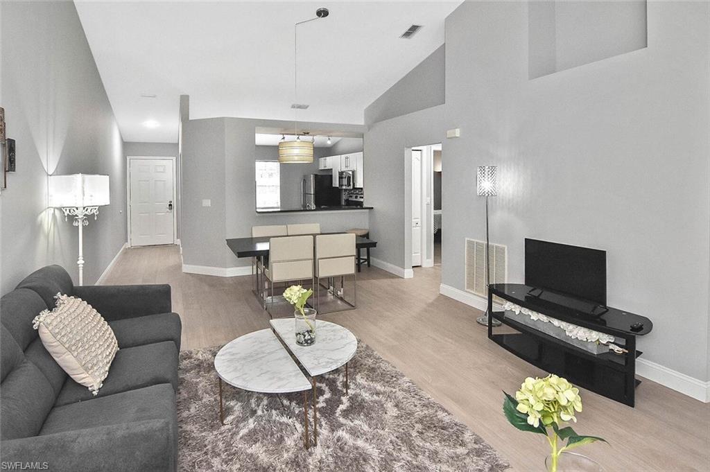 8075 Tiger Cove, Unit 1711 Naples, FL 34113 - Photo 6 of 42 a living room with furniture and a flat screen tv