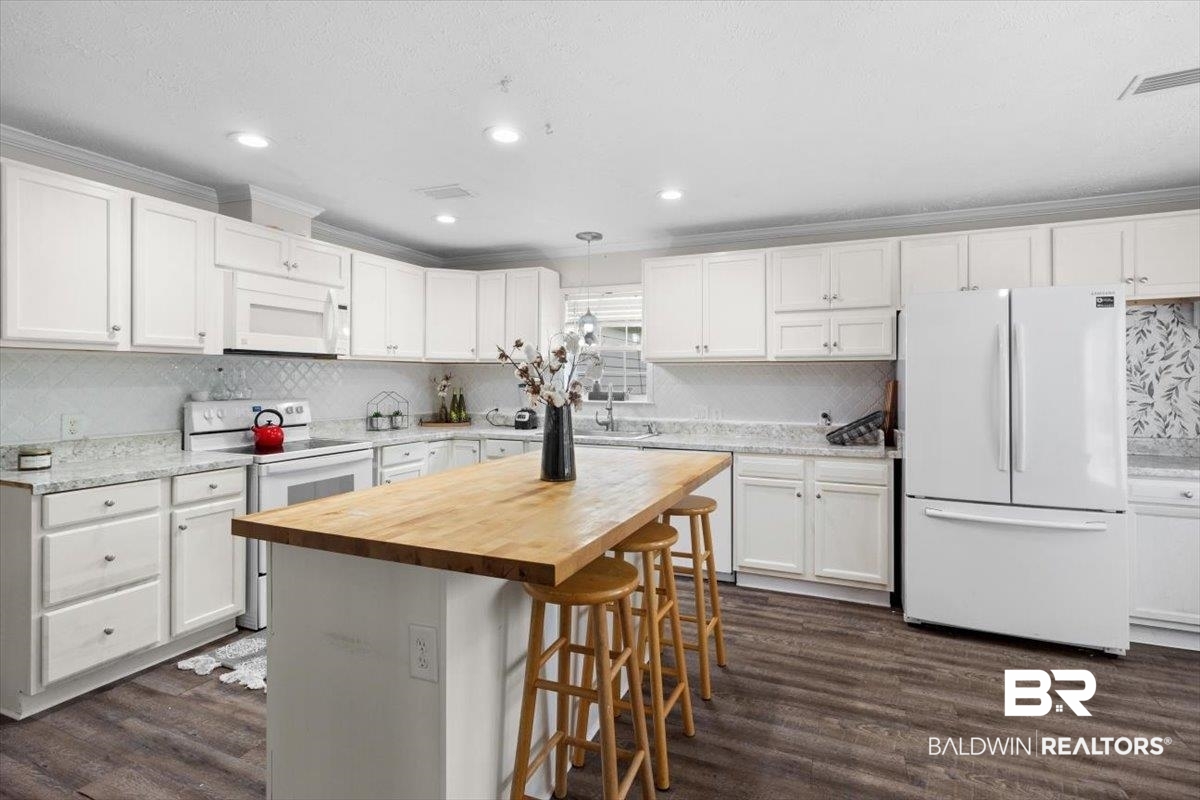 6971 March Road Theodore, AL 36582 - Photo 8 of 26 Kitchen with white appliances, visible vents, butcher block countertops, and white cabinetry