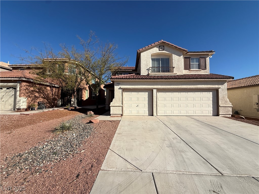 Mediterranean / spanish-style house with stucco siding, a tiled roof, driveway, and a garage