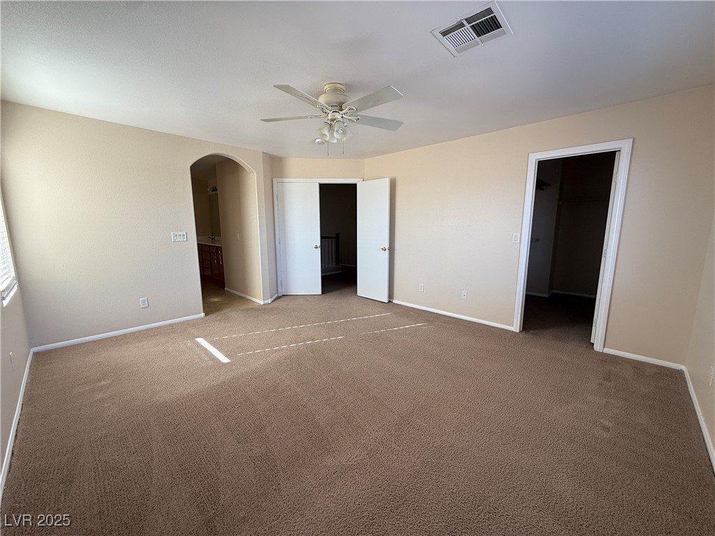 9950 Shadow Grove Avenue Las Vegas, NV 89148 - Photo 21 of 37 Unfurnished bedroom featuring arched walkways, carpet flooring, a spacious closet, and ceiling fan