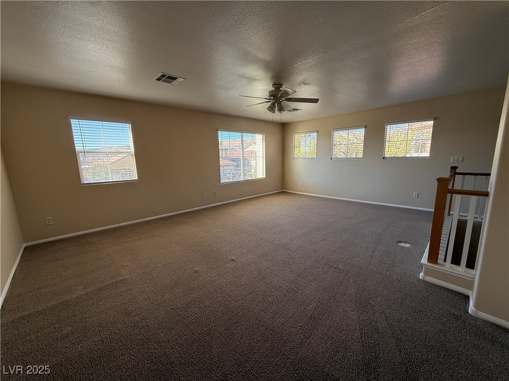 9950 Shadow Grove Avenue Las Vegas, NV 89148 - Photo 32 of 37 Unfurnished room with dark carpet, a textured ceiling, and a ceiling fan