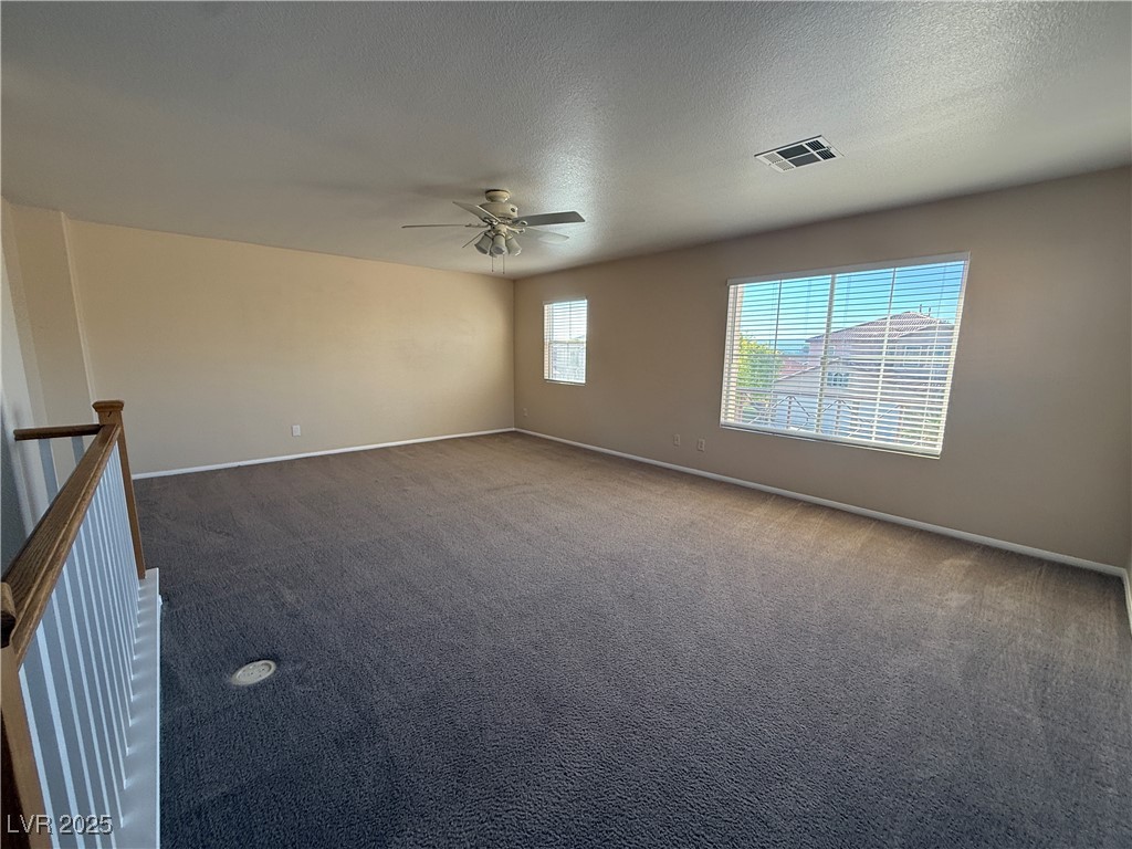 9950 Shadow Grove Avenue Las Vegas, NV 89148 - Photo 33 of 37 Spare room featuring dark colored carpet, a textured ceiling, and a ceiling fan