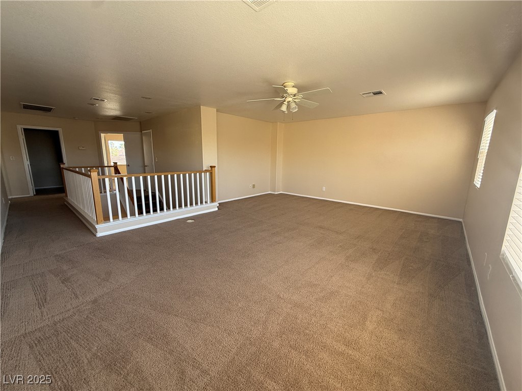 9950 Shadow Grove Avenue Las Vegas, NV 89148 - Photo 34 of 37 Unfurnished room featuring light colored carpet, a textured ceiling, and a ceiling fan
