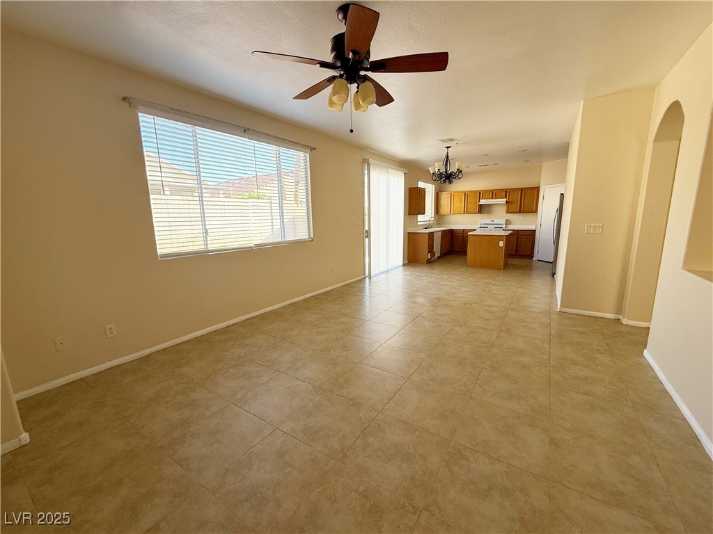 9950 Shadow Grove Avenue Las Vegas, NV 89148 - Photo 7 of 37 Unfurnished living room featuring a chandelier, light tile patterned flooring, and ceiling fan