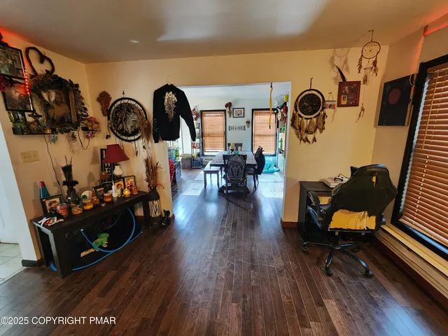 a view of a hallway with wooden floor and stairs