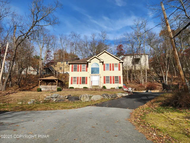 a view of a white house with a yard covered in snow