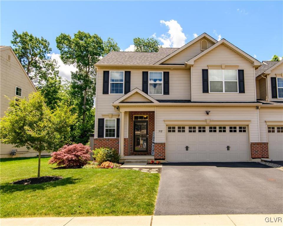 a view of a white house with a yard and potted plants