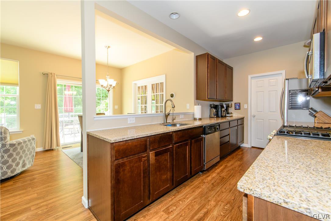 512 Racite Road Alburtis, PA 18011 - Photo 7 of 32 a large kitchen with stainless steel appliances granite countertop sink stove and wooden floor