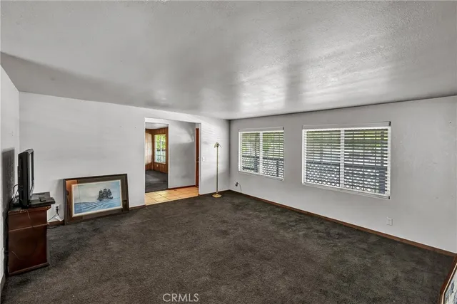 a view of an empty room with a fireplace and a window