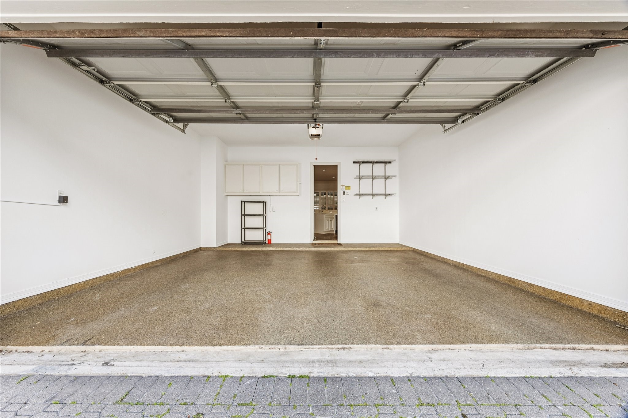 5823 Augusta Court Houston, TX 77057 - Photo 42 of 44 Spacious, clean and freshly painted garage with a polished floor, overhead storage, and an open door leading inside. Ideal for parking or extra storage space.
