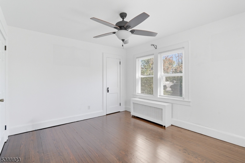 115 Billian Street, Unit 2 Bridgewater, NJ 08807 - Photo 2 of 10 an empty room with wooden floor chandelier fan and windows