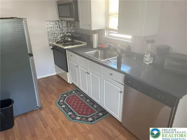 a kitchen with a sink stove and cabinets