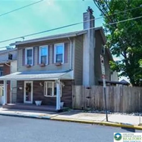 a view of a house with a small yard and wooden fence