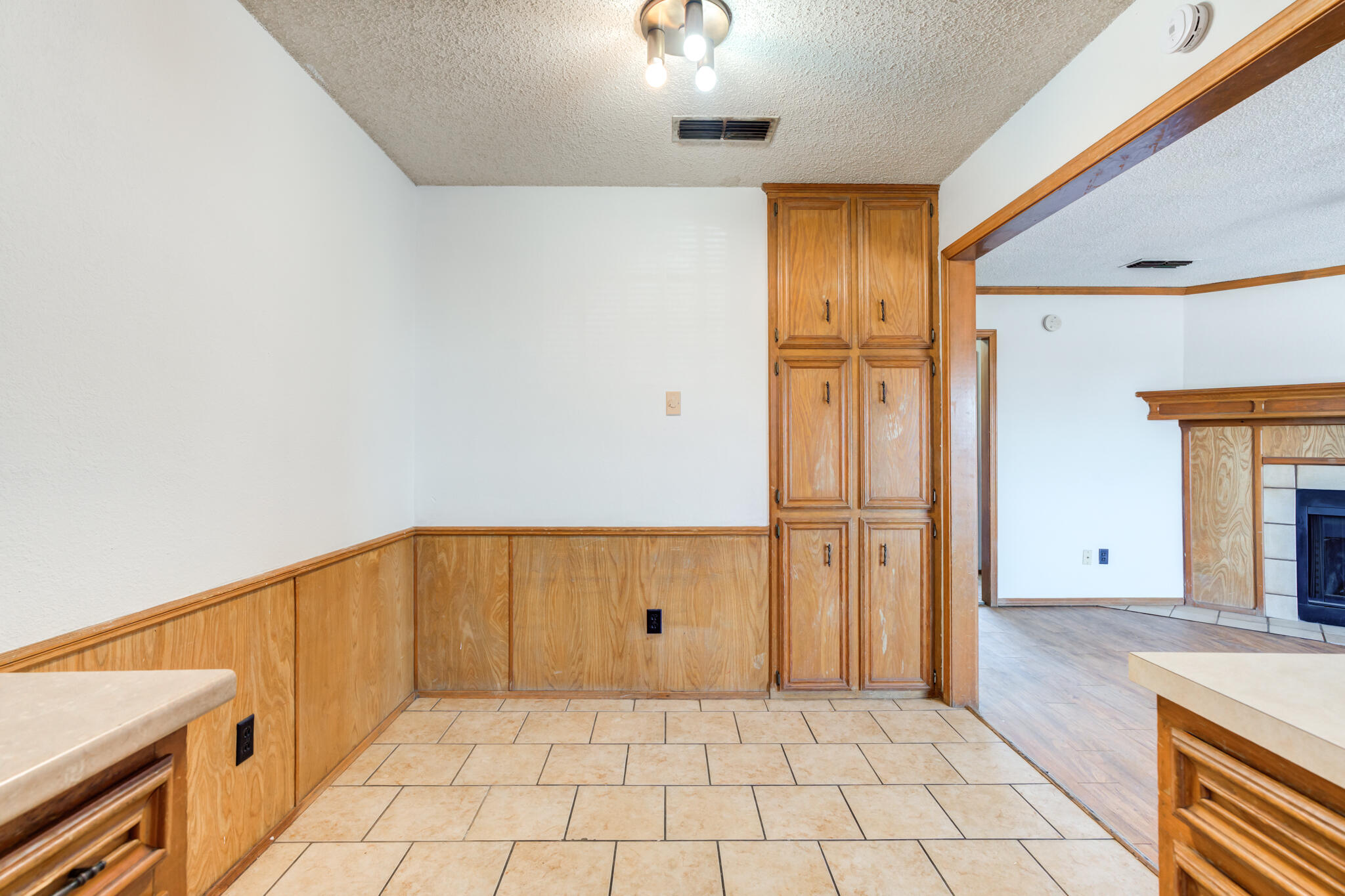 7405 Waco Avenue Lubbock, TX 79423 - Photo 23 of 29 a view of a refrigerator in kitchen and an empty room in wooden floor