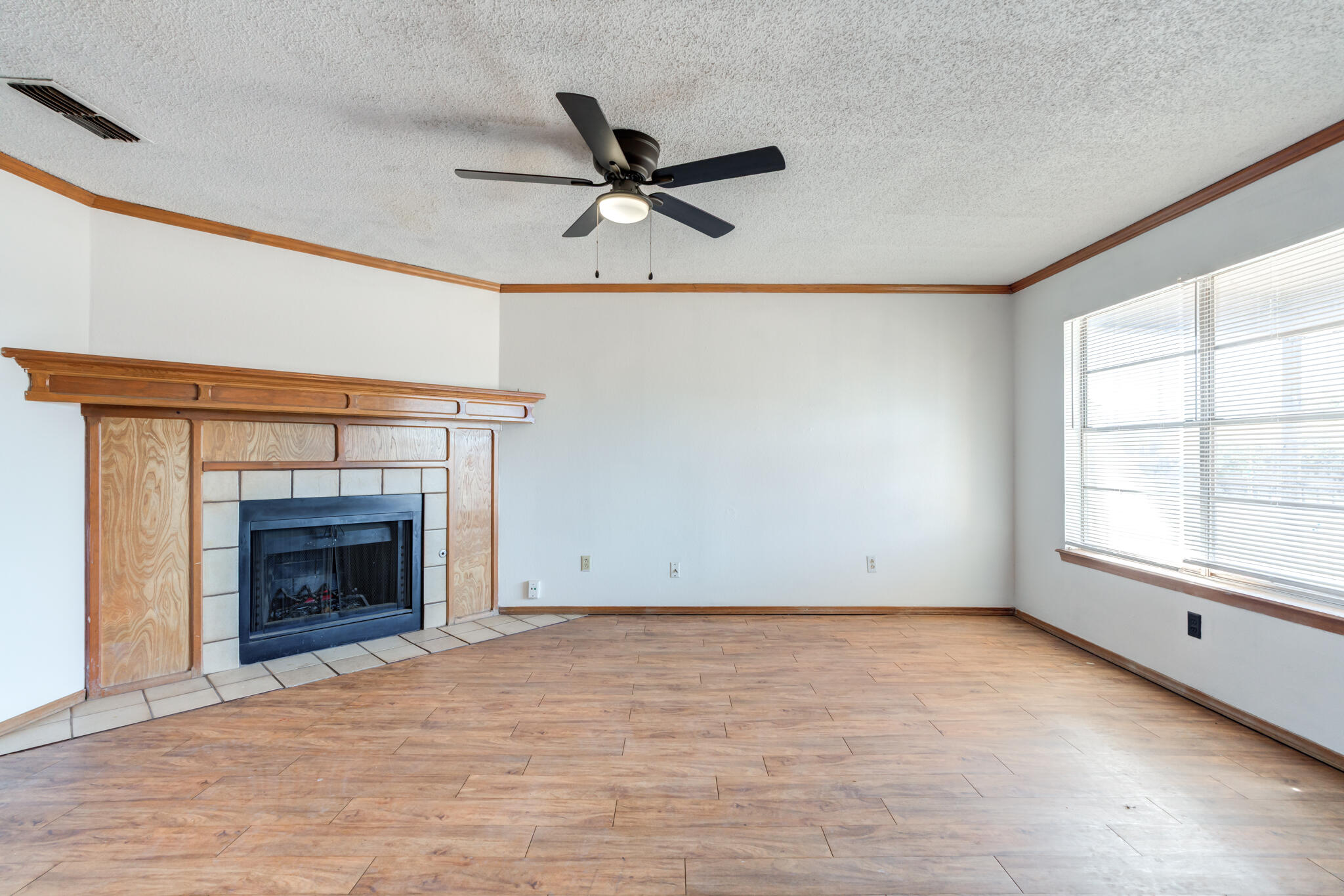 7405 Waco Avenue Lubbock, TX 79423 - Photo 8 of 29 a view of an empty room with a fireplace and a window