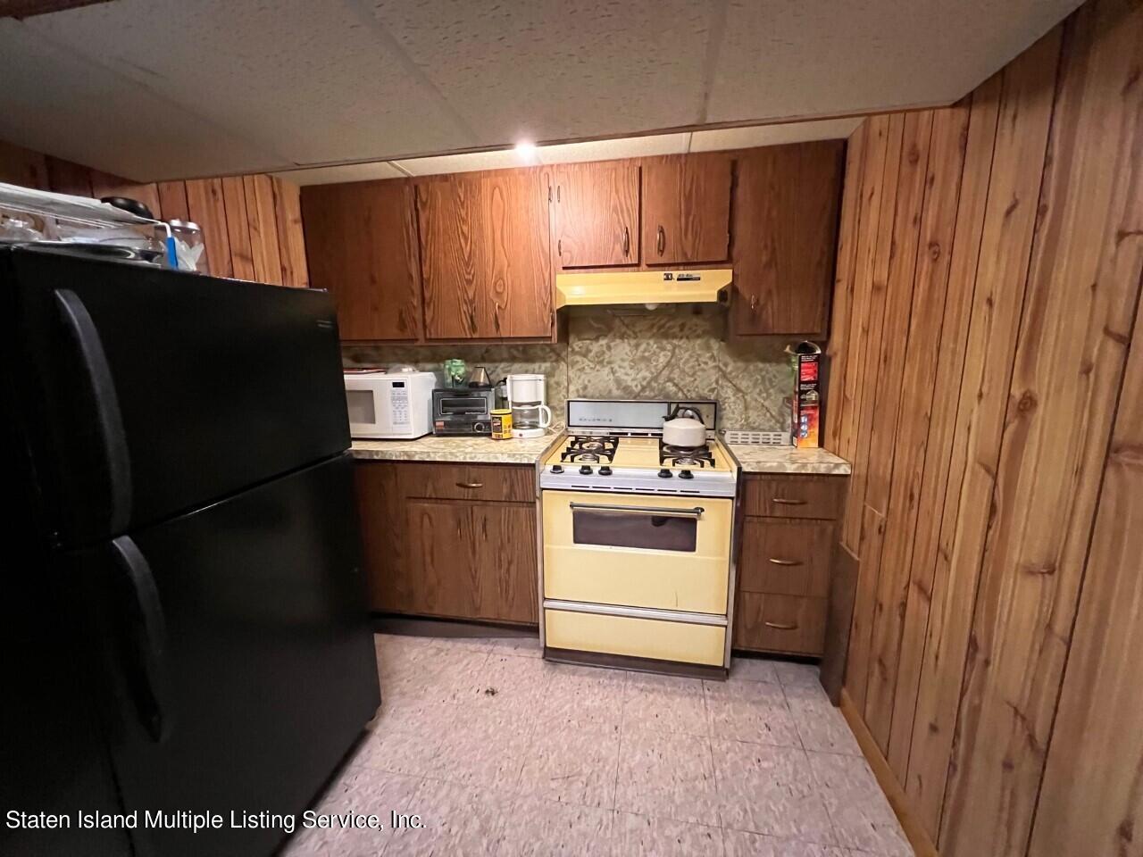 2760 Amboy Road Staten Island, NY 10306 - Photo 12 of 16 a kitchen with a refrigerator stove and cabinets
