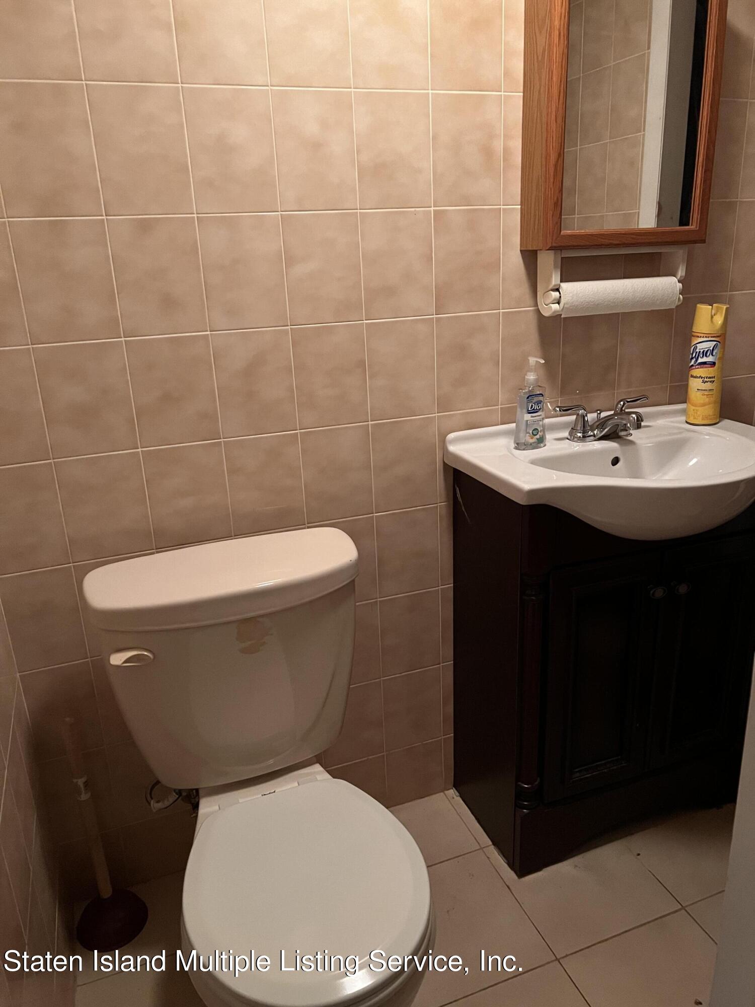 2760 Amboy Road Staten Island, NY 10306 - Photo 16 of 16 a bathroom with a toilet a sink and mirror