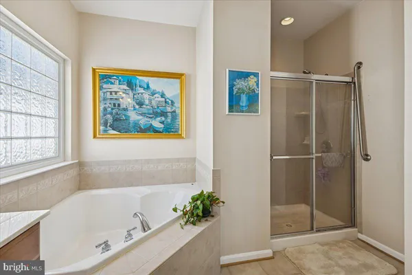a bathroom with a tub a sink and a large mirror