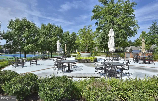 a view of a patio with table and chairs potted plants and a large tree