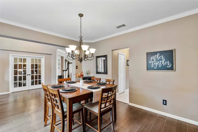 a view of a dining room with furniture wooden floor and chandelier