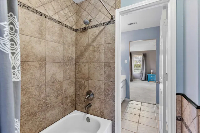 a bed sitting in a bedroom next to a bathroom