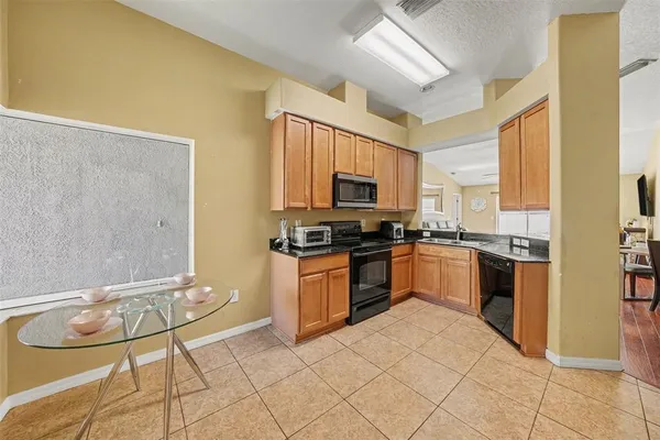 a kitchen with stainless steel appliances a stove a sink and white cabinets