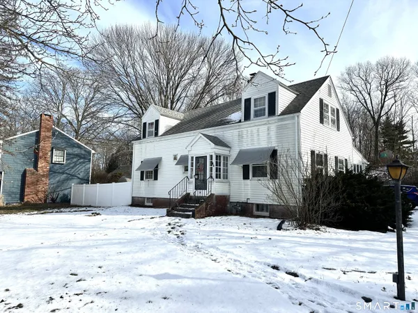 a front view of a house with a yard covered in snow
