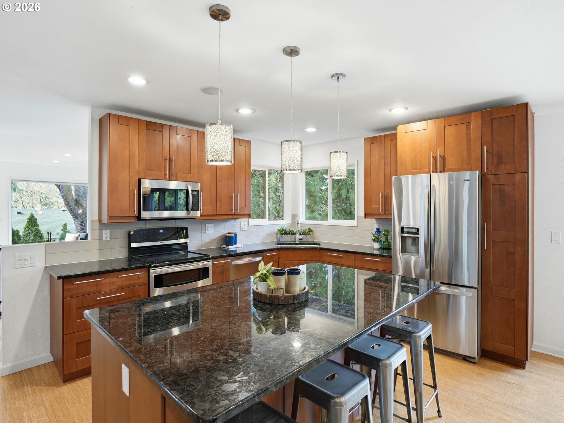 4148 Southwest 43rd Avenue Portland, OR 97221 - Photo 11 of 44 a kitchen with stainless steel appliances granite countertop a stove top oven a sink dishwasher a dining table and chairs with wooden floor