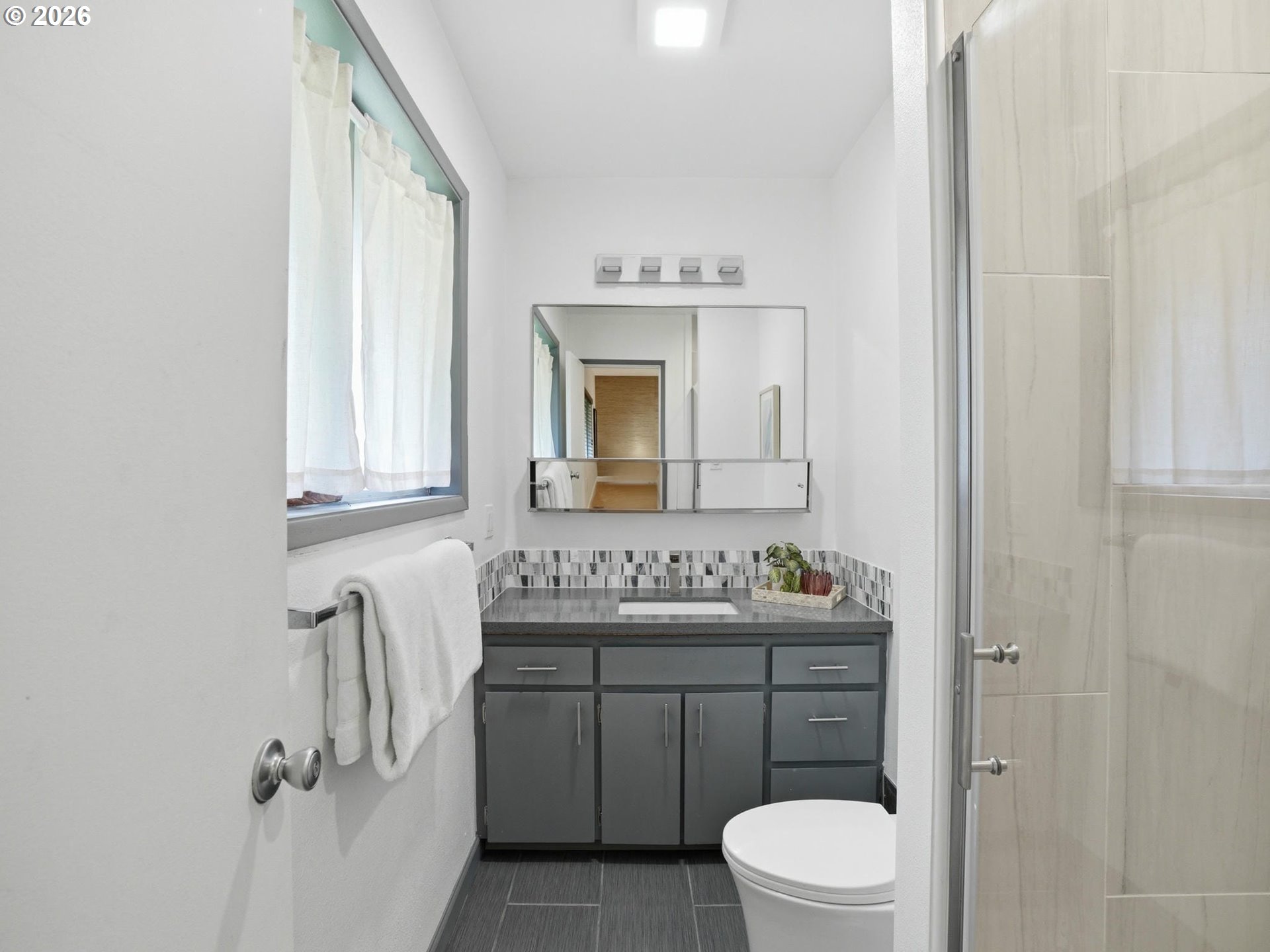 4148 Southwest 43rd Avenue Portland, OR 97221 - Photo 18 of 44 a bathroom with a toilet sink vanity granite and mirror