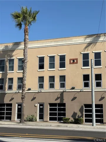 a front view of a building with garage and plants