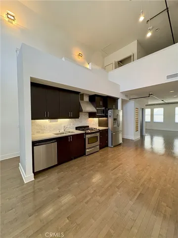a large white kitchen with stainless steel appliances kitchen island a large counter space a sink and appliances