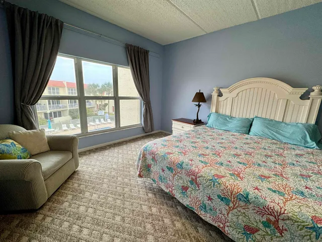 a bedroom with a bed and a large window