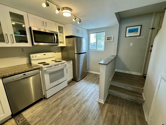 a kitchen with a sink a microwave a refrigerator and cabinets