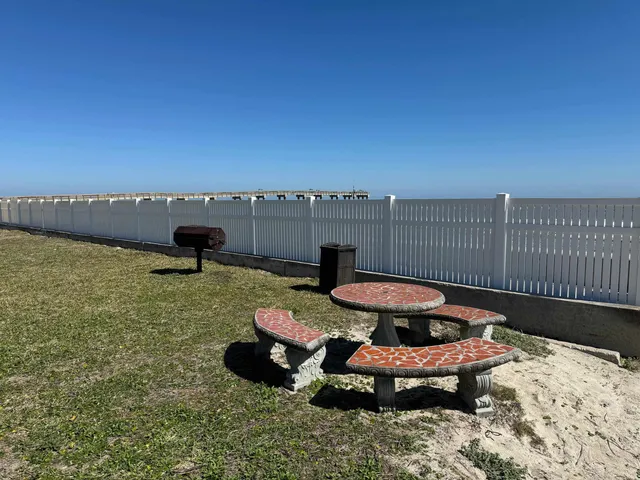 a view of a backyard with table and chairs and a barbeque